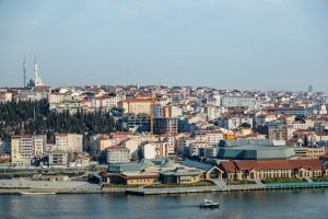 A scenic aerial view of Istanbul's skyline along the Bosphorus, capturing urban sprawl and a prominent mosque.