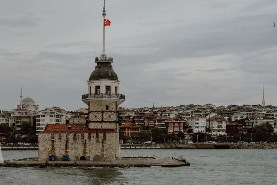 View of the iconic Maiden's Tower in Istanbul with cloudy skies and the cityscape in the background.